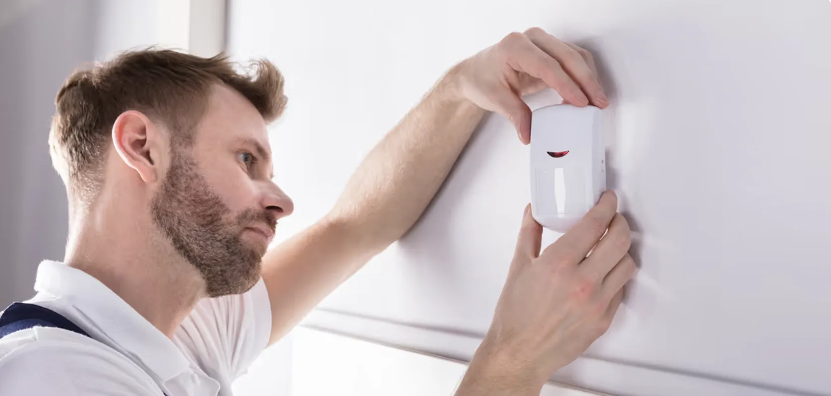 Installateur qualifié posant une alarme